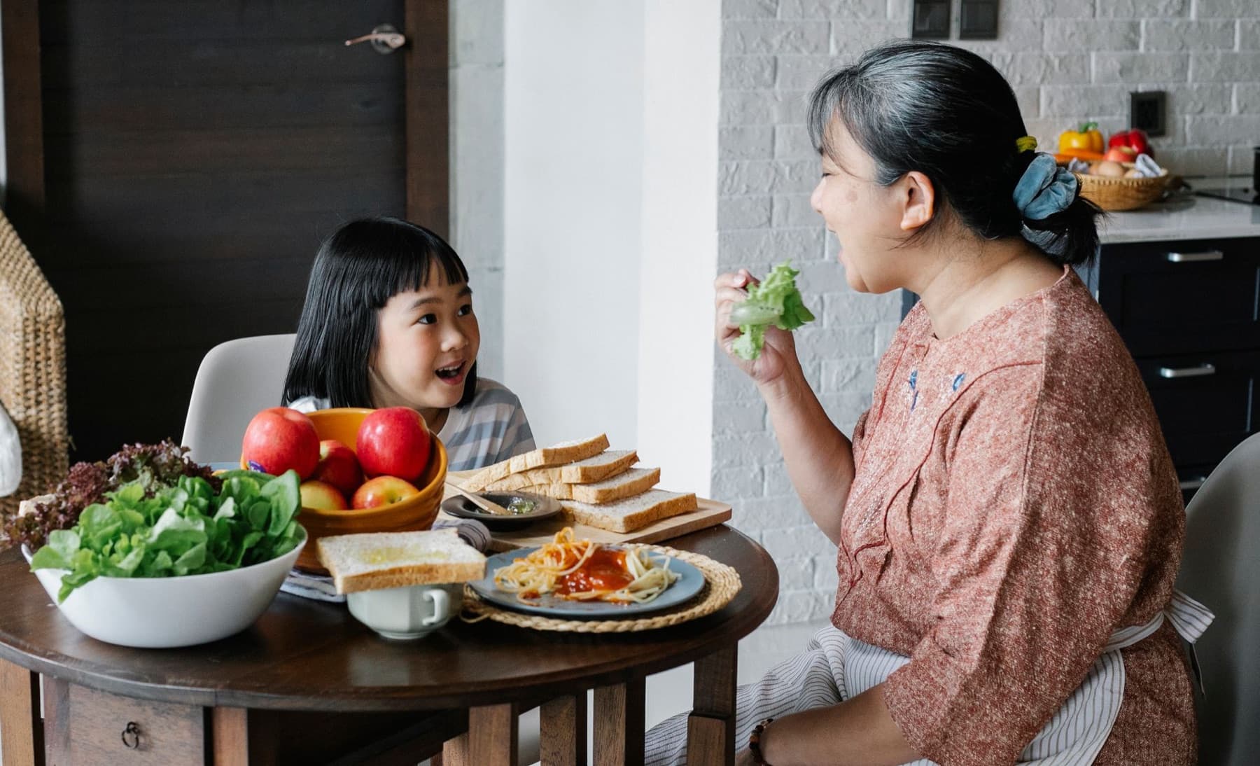 A grandmother serving a warm family meal at home in Singapore